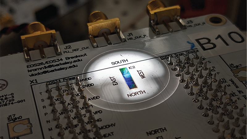 A packaged circuit board containing the chip placed under microscope in probe station during an experiment. The first-of-its-kind silicon chip combines both the quantum light-generating components (photonics) with classical electronic control circuits — all packed into an area measuring just one millimeter by one millimeter.